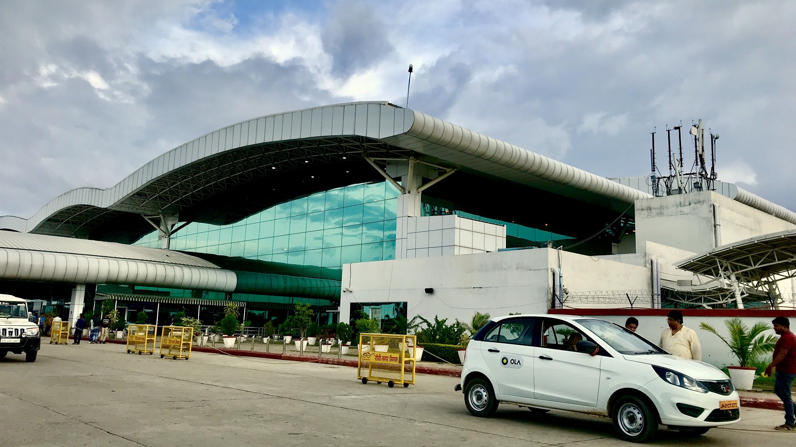 Exterior of Birsa Munda Airport terminal in Ranchi with the curved glass facade and curb roadway