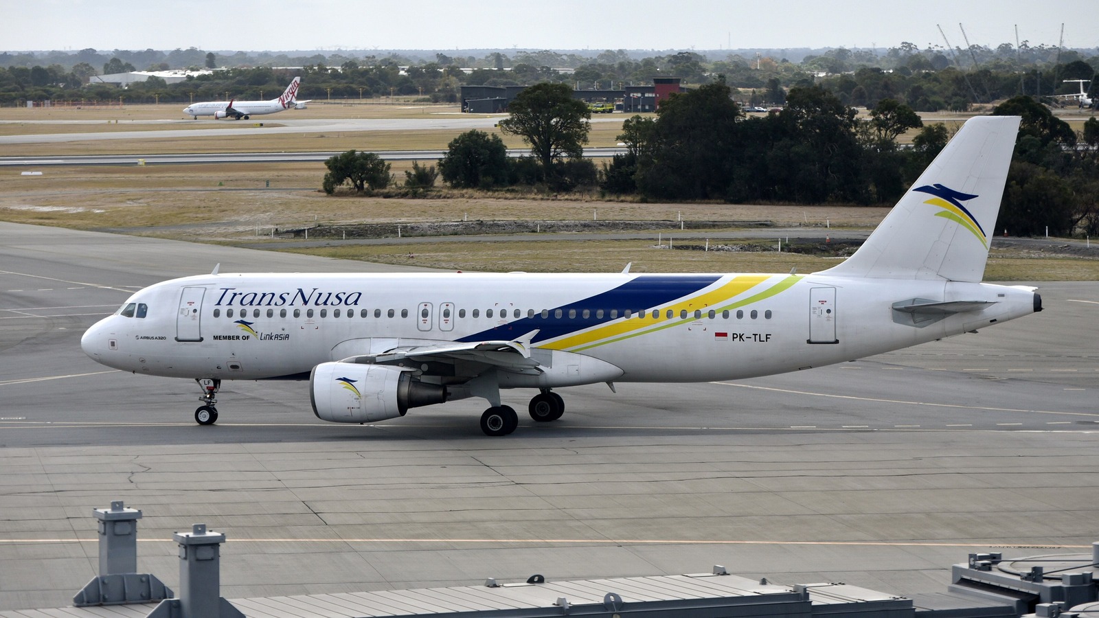 A TransNusa Airbus A320 taxiing at Perth Airport, with the TransNusa titles and Indonesian registration visible.