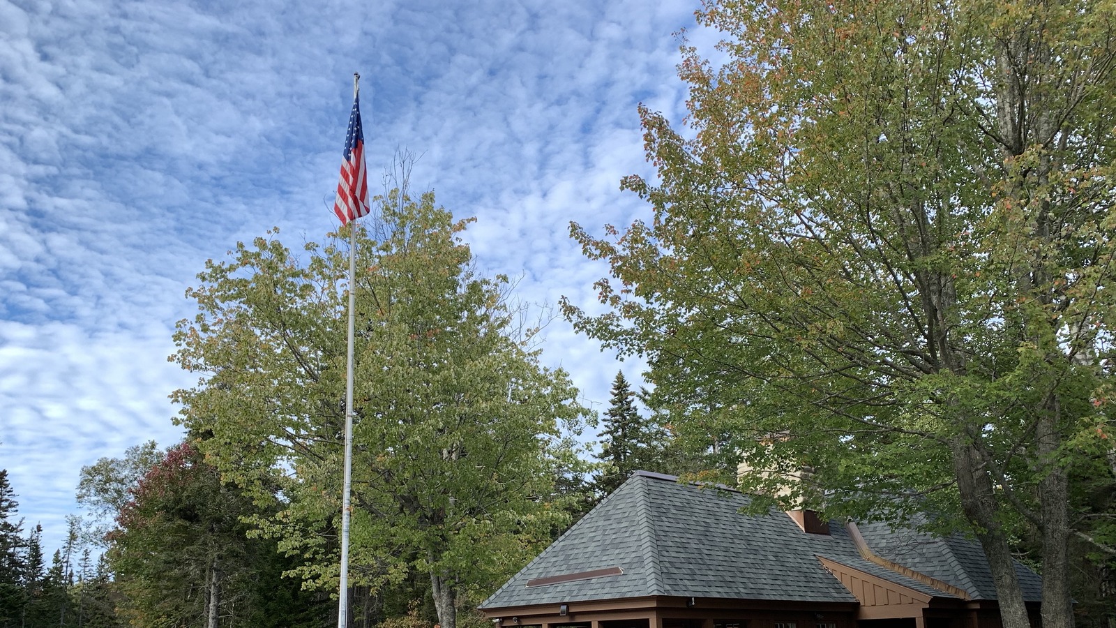 Wooden ranger kiosk and flagpole at the Seawall Campground entrance in Acadia National Park