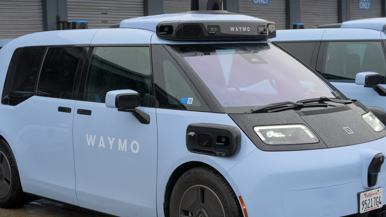 Waymo Zeekr autonomous vehicle with roof sensors and visible Waymo branding at the Bayshore depot