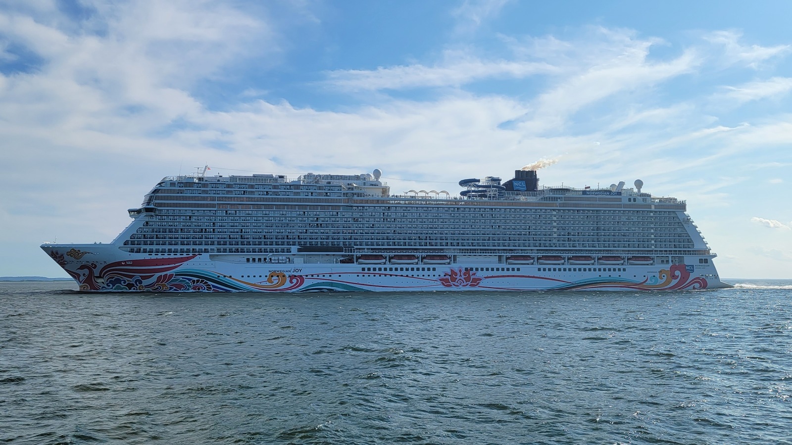 Norwegian Joy cruise ship underway at sea showing its hull art