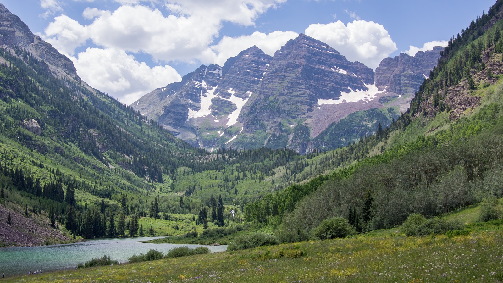 The Maroon Bells rise above Maroon Lake near Aspen, Colorado, with the two peaks reflected in the water.