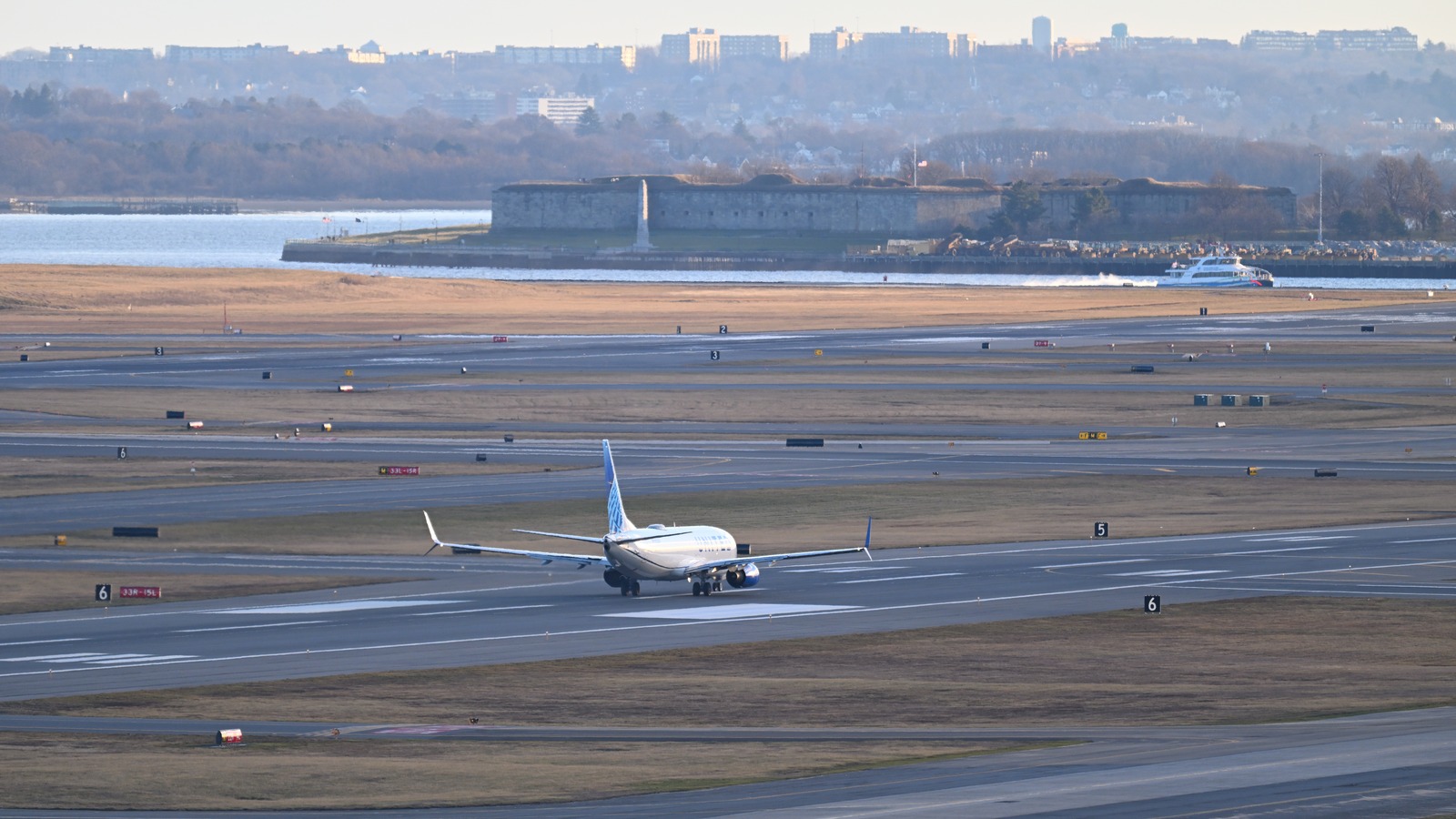United Airlines Boeing 737-800 on its takeoff roll at Boston Logan Airport on a clear winter afternoon