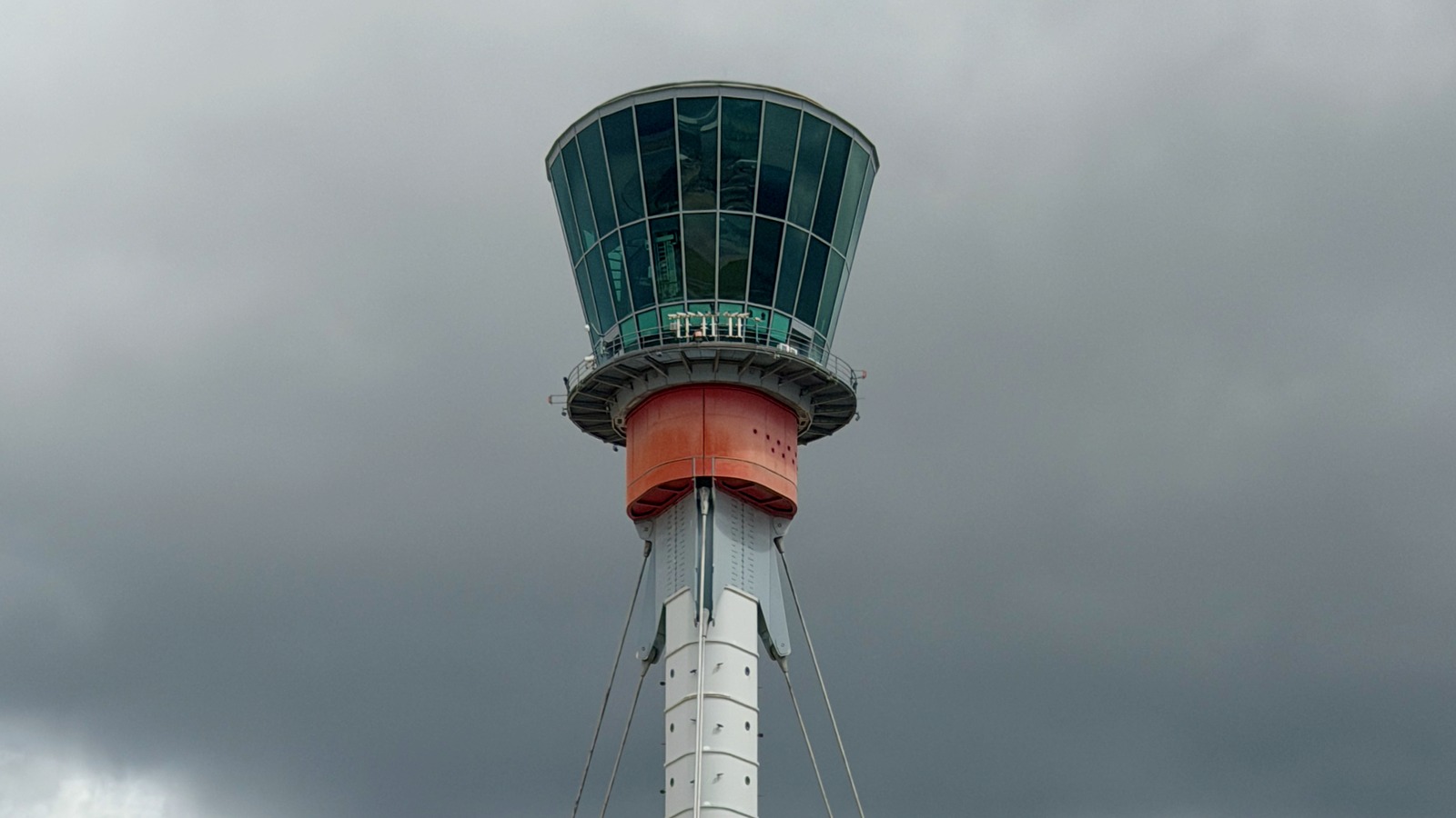 London Heathrow Airport control tower with glass cab against a cloudy sky