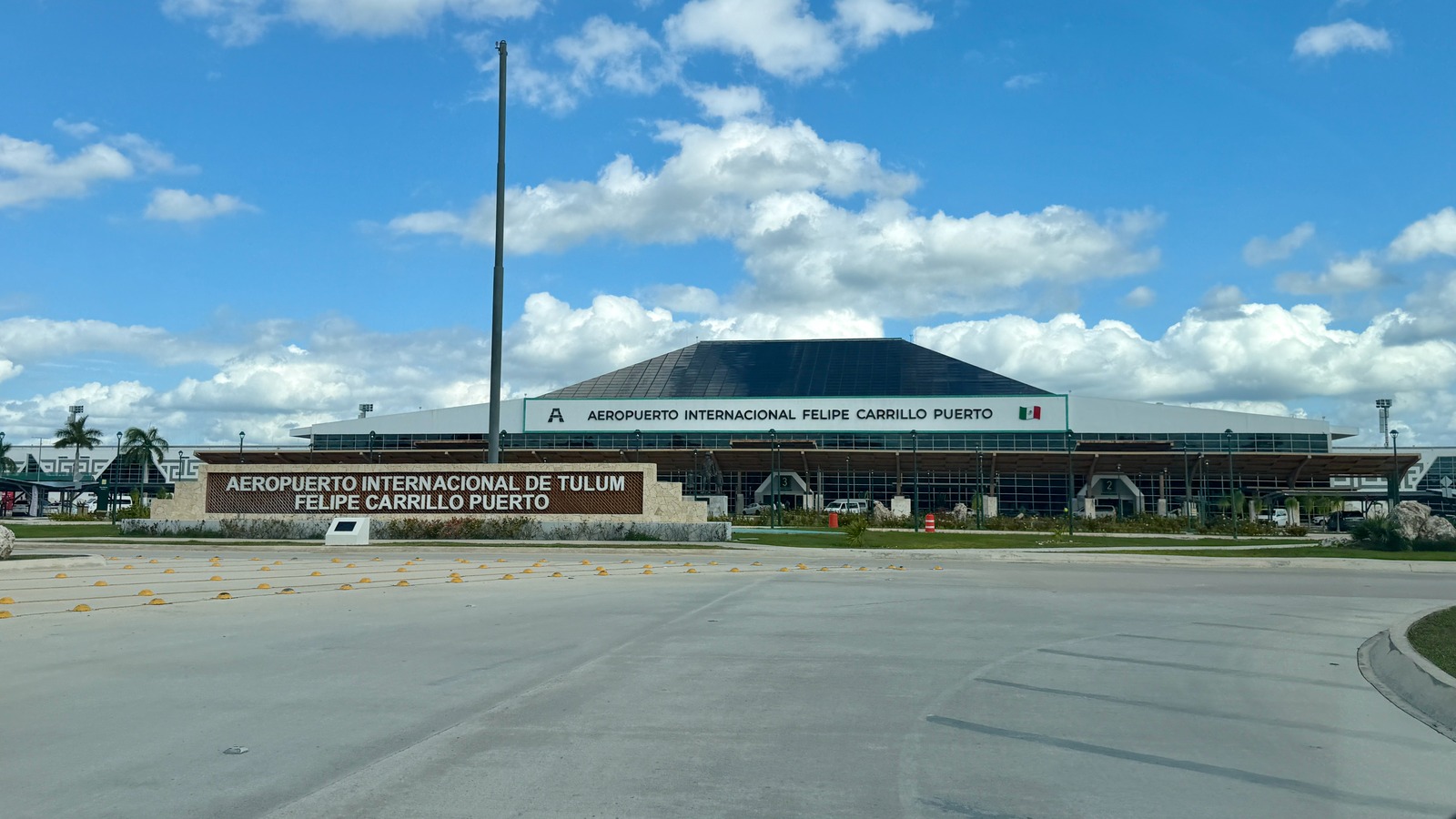 Tulum International Airport terminal exterior with Felipe Carrillo Puerto signage under a blue sky