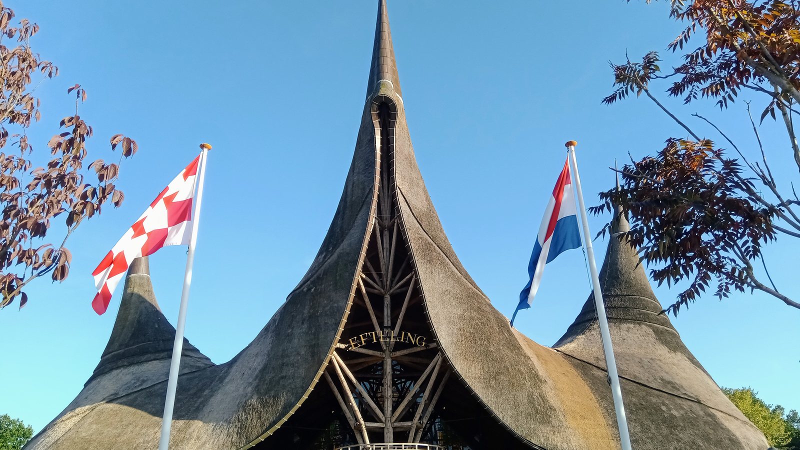 The thatched roof and spires of the House of the Five Senses, Efteling's main entrance, under a blue sky in July 2022