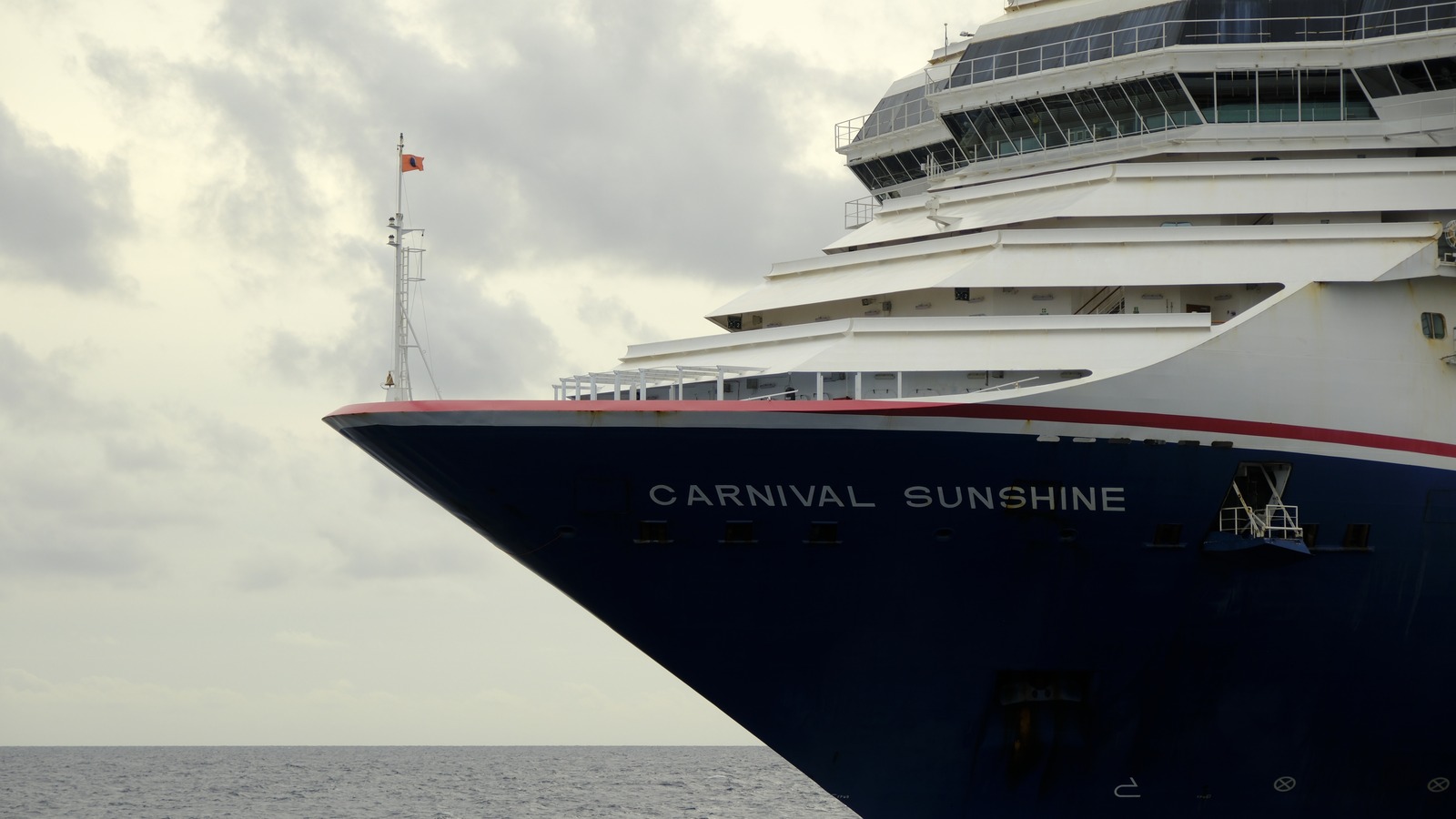 Bow of the Carnival Sunshine cruise ship at sea showing the ship name on the hull