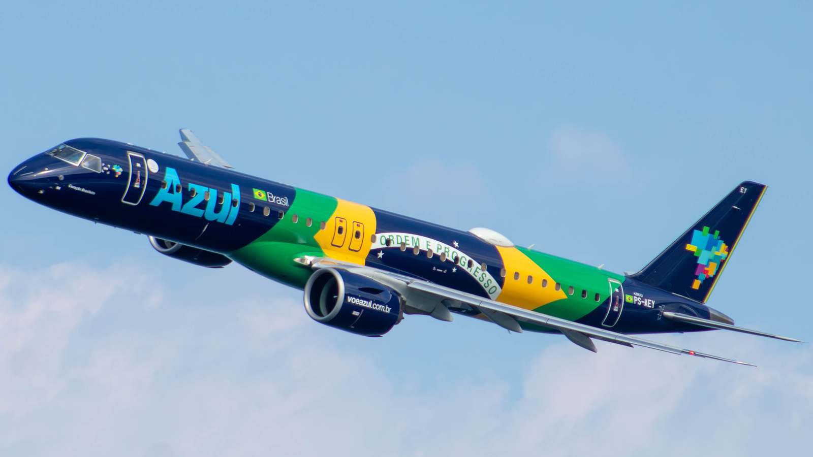 Azul Embraer E195-E2 in Brazilian flag livery climbing out against a blue sky