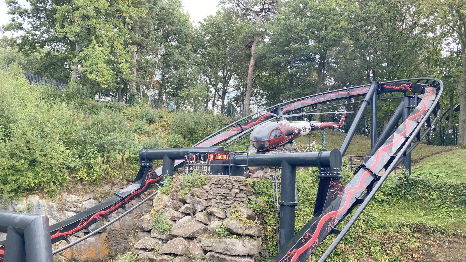 Nemesis Reborn train on its red and black track in Forbidden Valley at Alton Towers