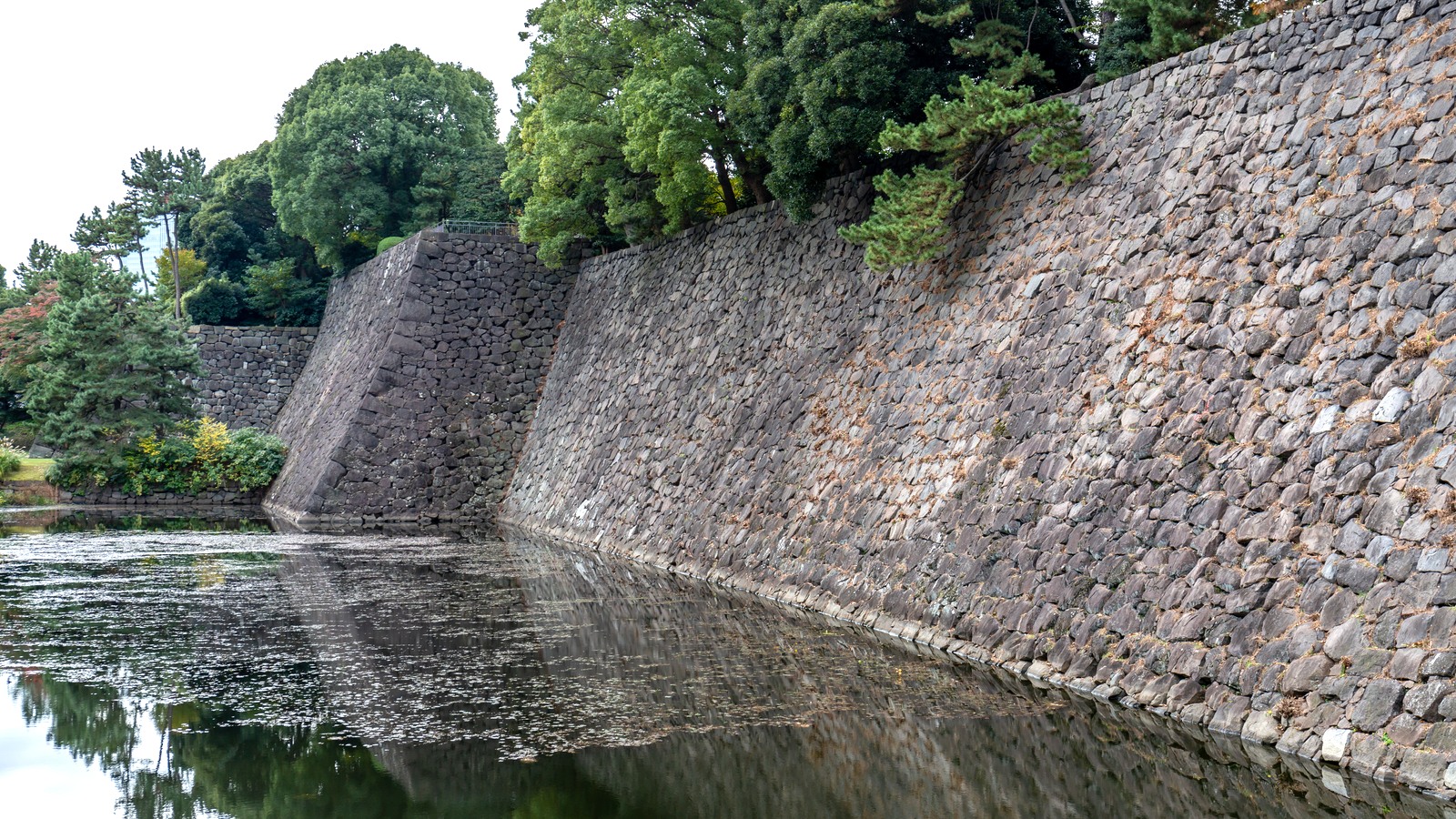 Massive stone ramparts beside the moat at the Edo Castle ruins