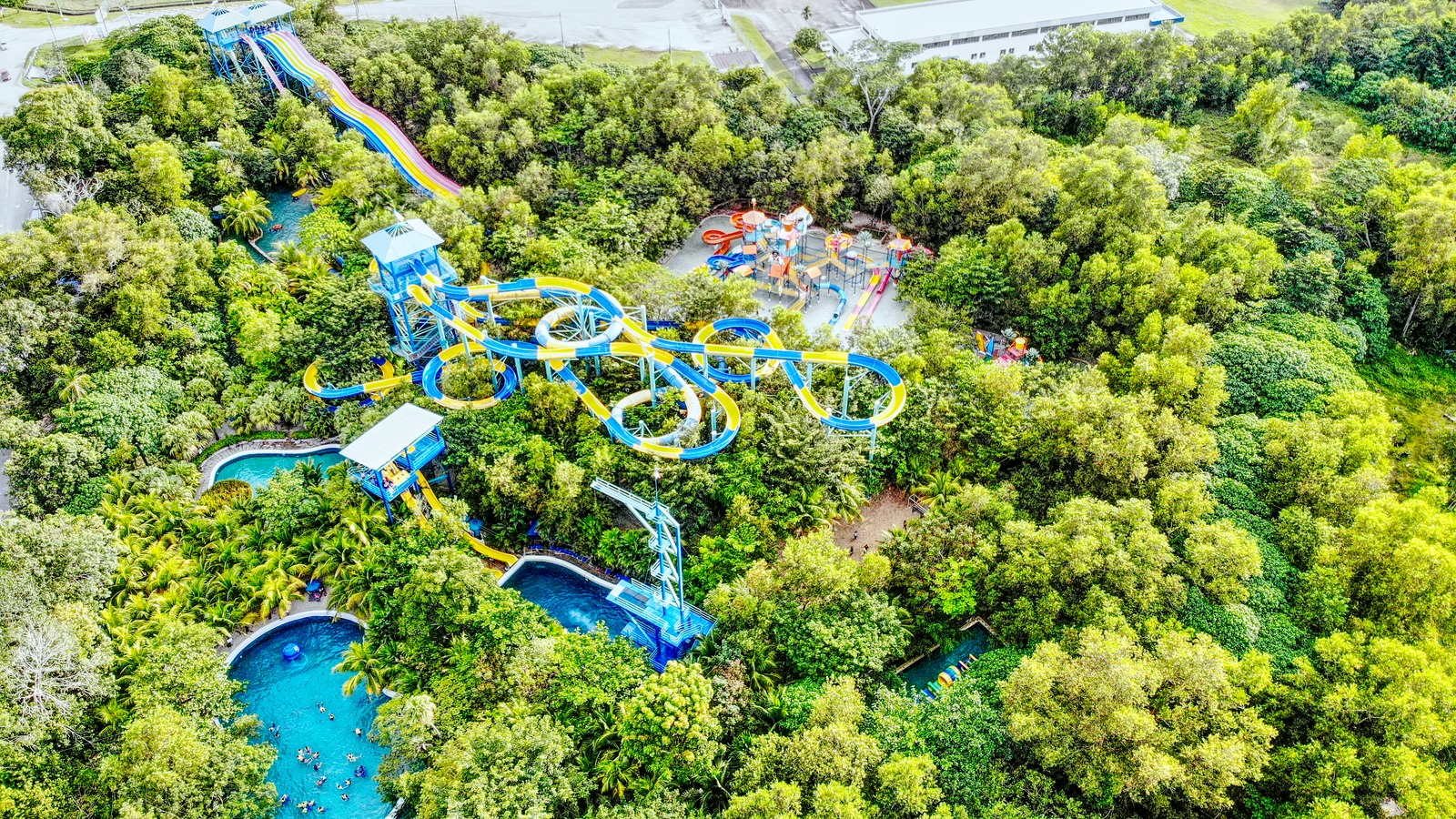 Aerial view of Waterplay slides and pools surrounded by forest at ESCAPE Penang