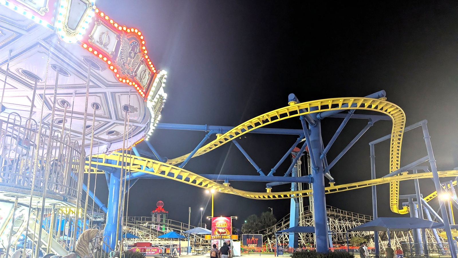 Yellow Freedom Flyer suspended coaster track at Fun Spot America Orlando at night