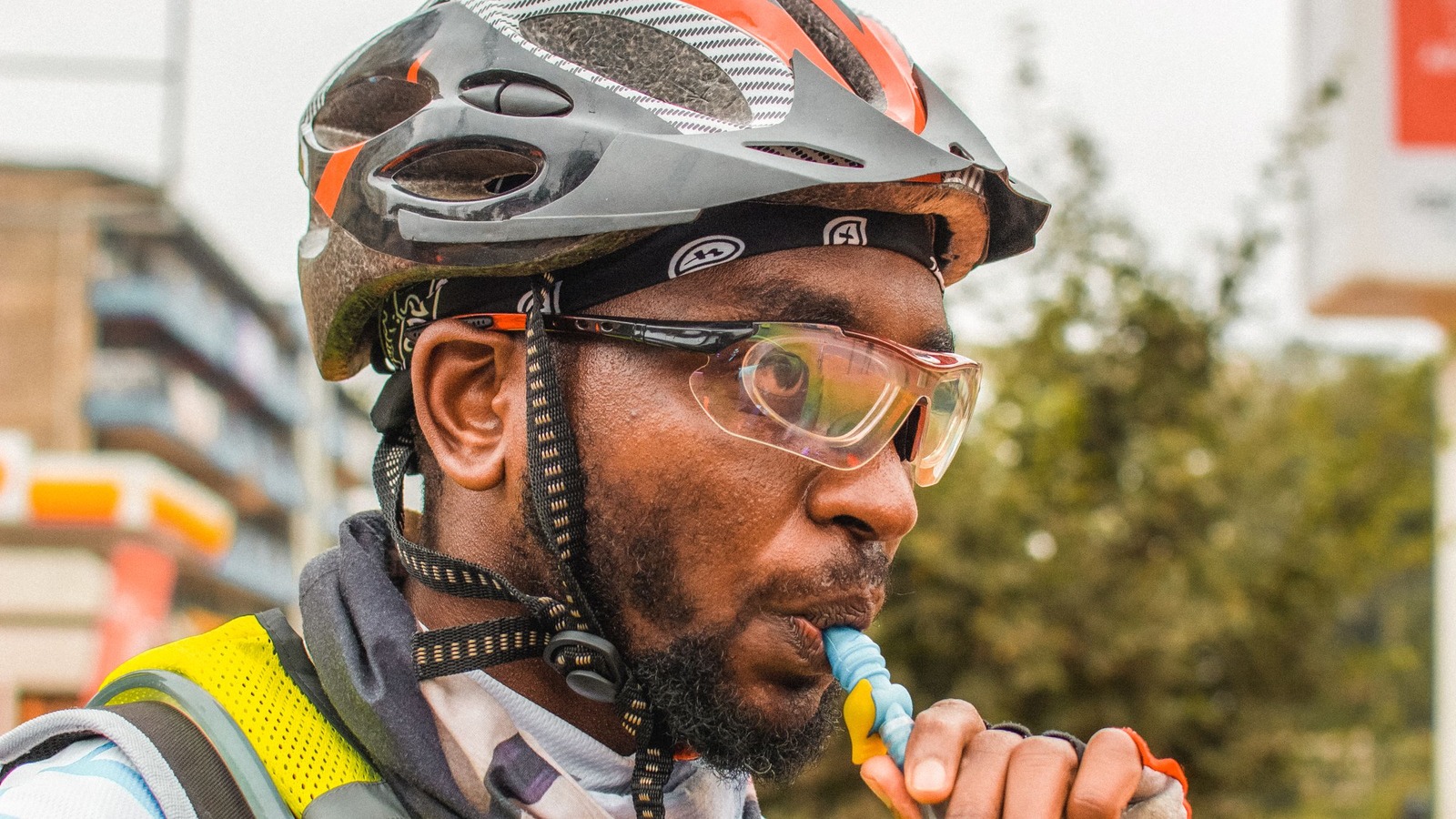 A cyclist drinking through a hydration pack tube.