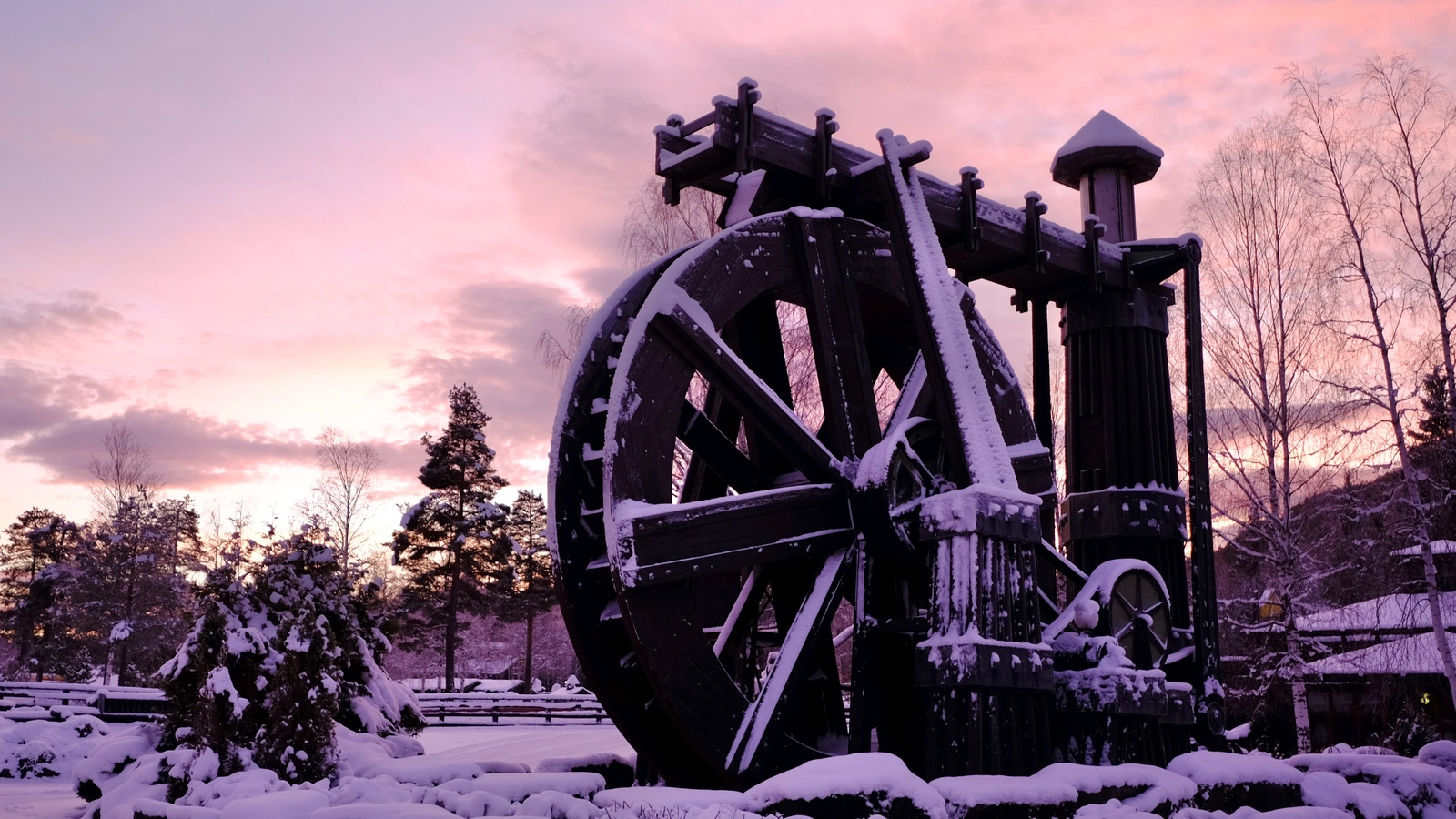 Snow-covered wooden Perpetuum Mobile wheel at Hunderfossen in December 2021