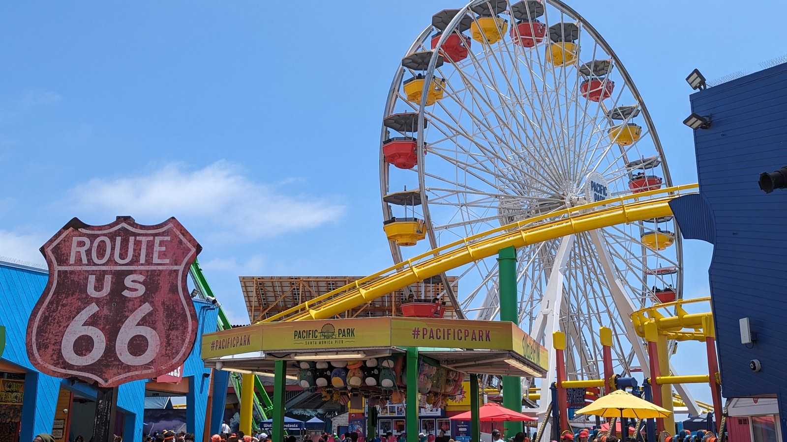 Route 66 entrance sign at Pacific Park with the wheel and coaster beyond