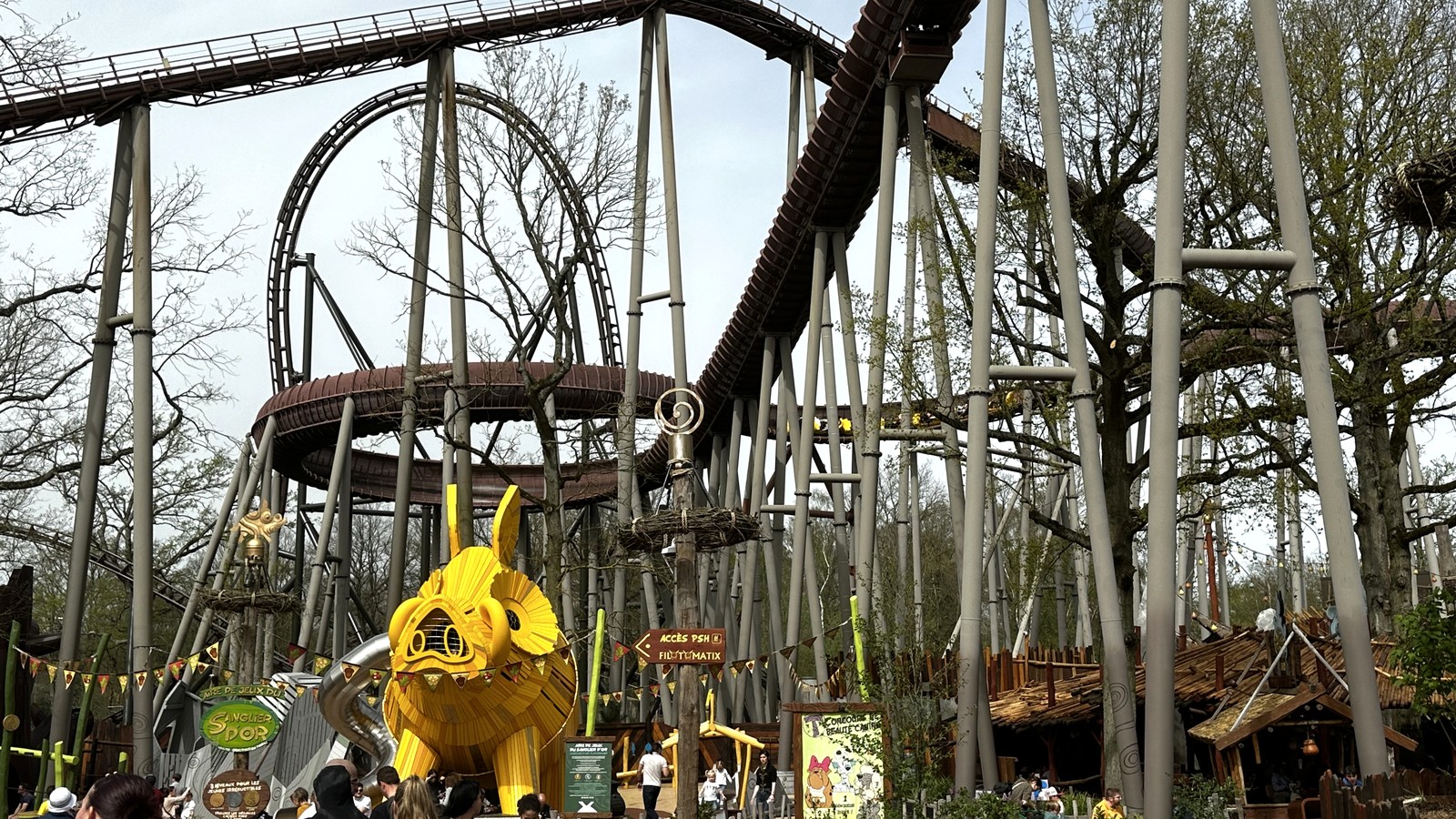 Trace du Hourra coaster and yellow boar sculpture at Parc Astérix