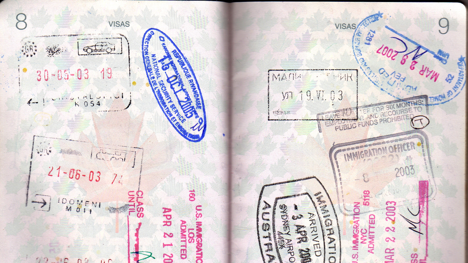 Passport pages filled with international entry and exit stamps
