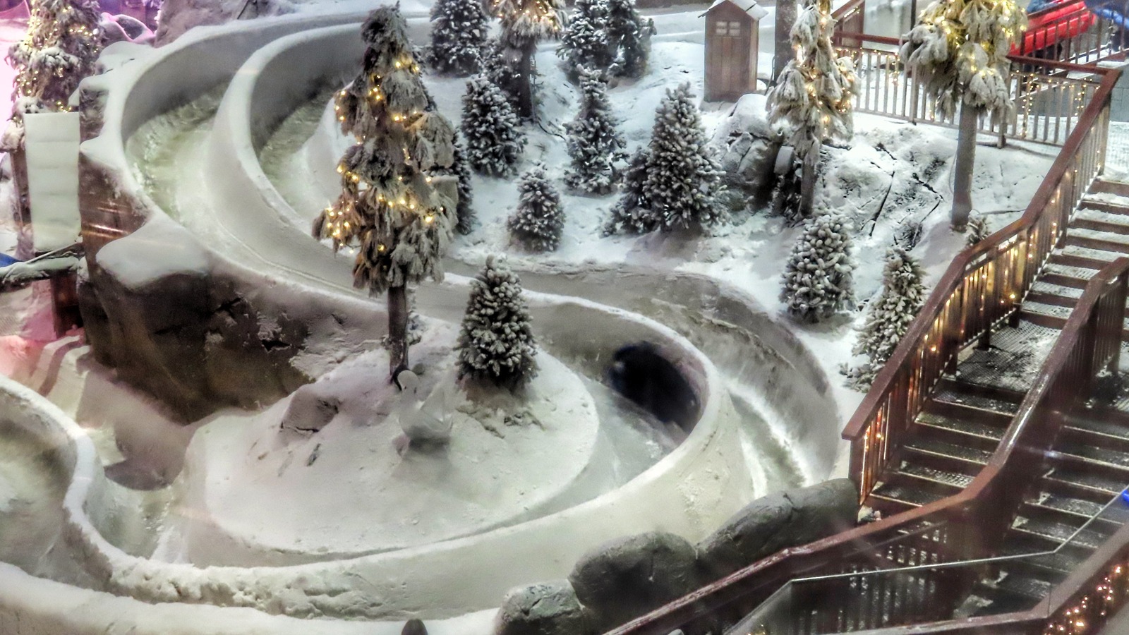 Snow tube slides and artificial evergreen trees inside Ski Dubai in Dubai