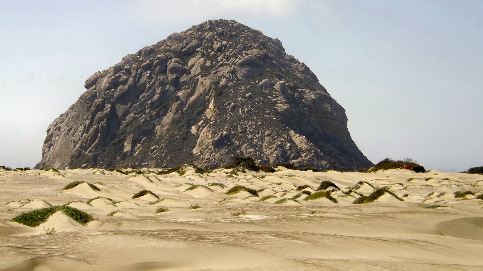 Morro Rock beside the beach and harbor in Morro Bay
