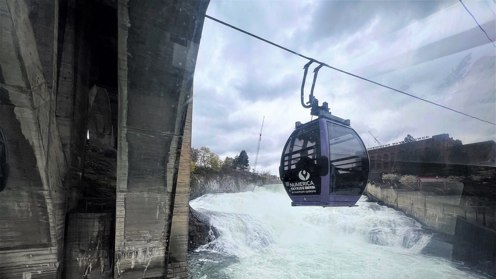 Numerica SkyRide gondola passing above Spokane Falls in Spokane Washington