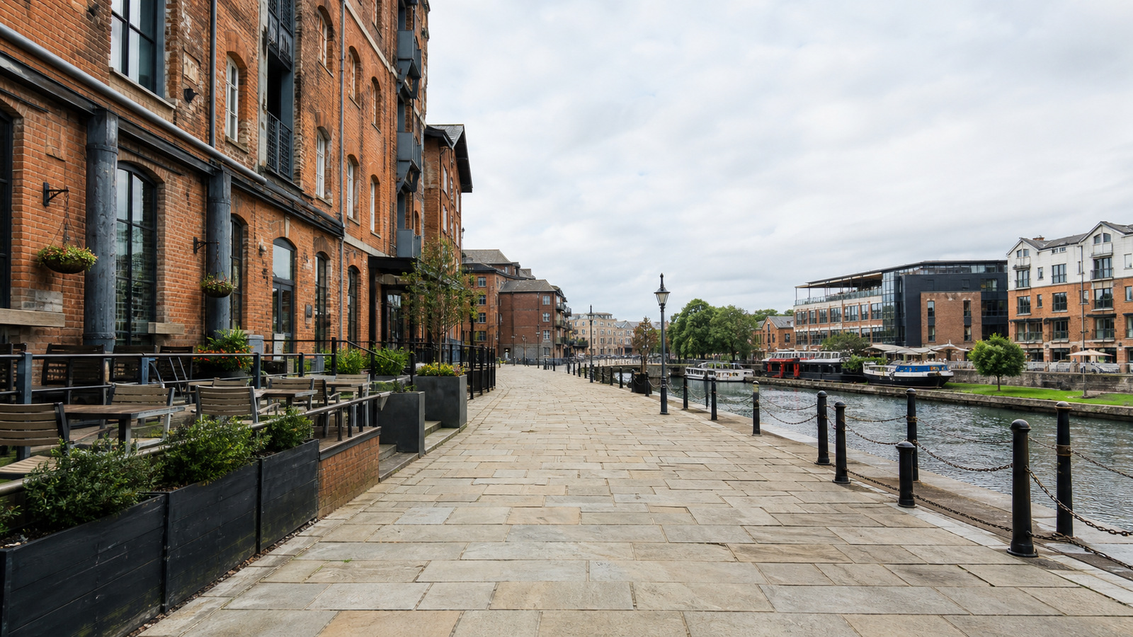 Representative Bristol-inspired harbor walkway with converted brick warehouses, terraces, and calm water
