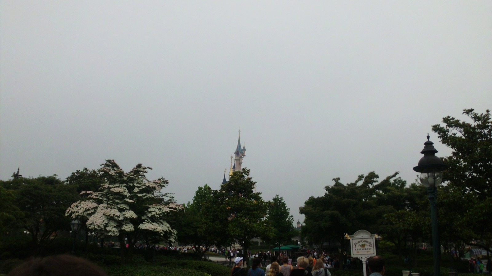 Le Chateau de la Belle au Bois Dormant rising above trees and Plaza Gardens Restaurant at Disneyland Park in Paris