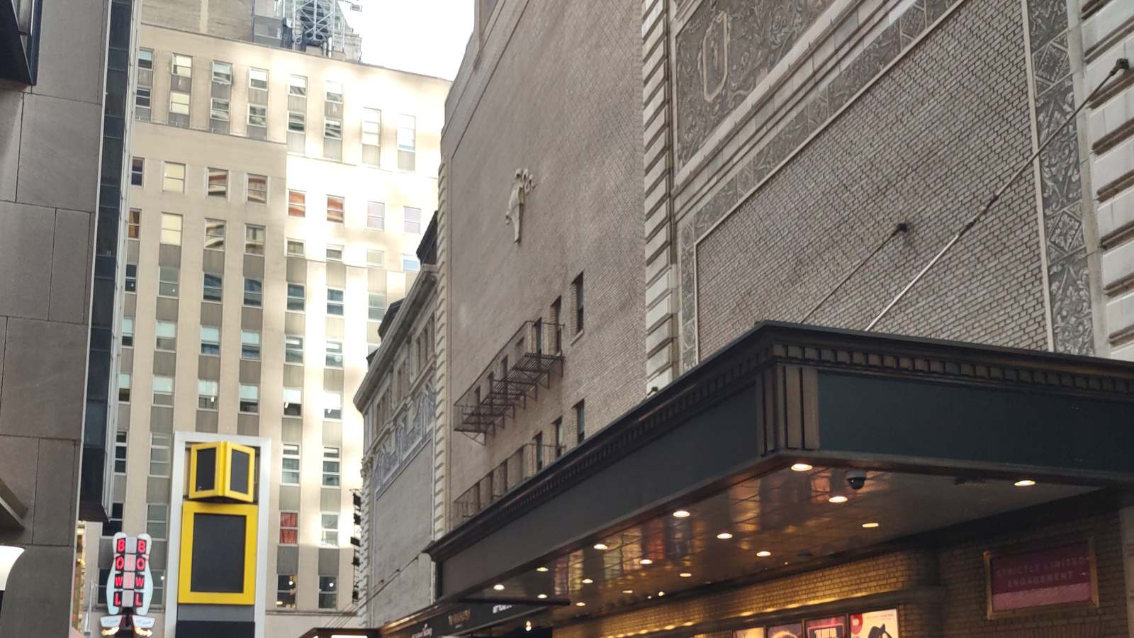 Theater facades and a marquee line Shubert Alley in Manhattan's Theater District.