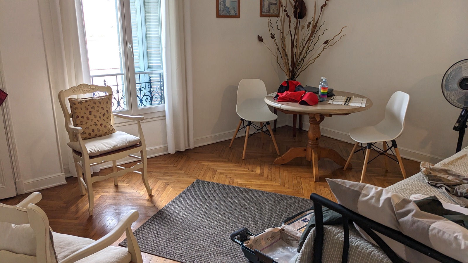 Living room of a Vrbo-booked vacation rental apartment in Nice, France, with a table, chairs, and balcony doors