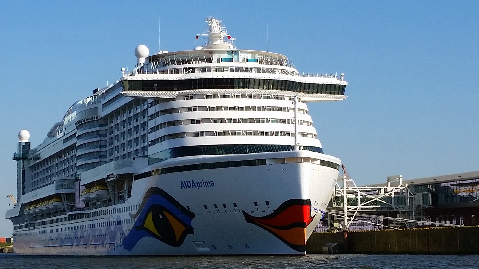 AIDAprima docked at Hamburg Cruise Center Steinwerder, bow and kiss-mouth livery facing the terminal