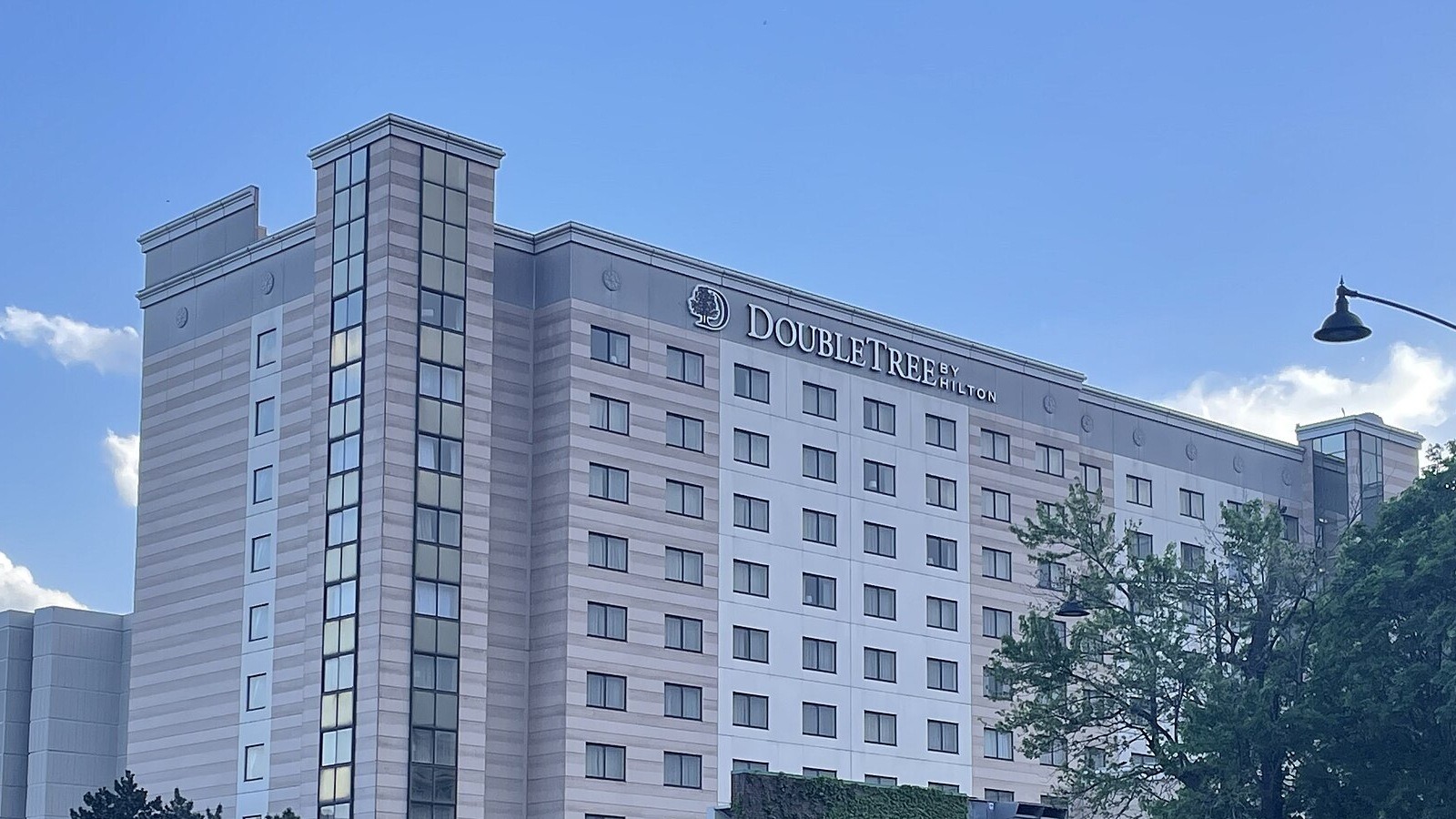 The DoubleTree by Hilton hotel tower near Chicago O'Hare airport in Rosemont, Illinois, under a blue sky