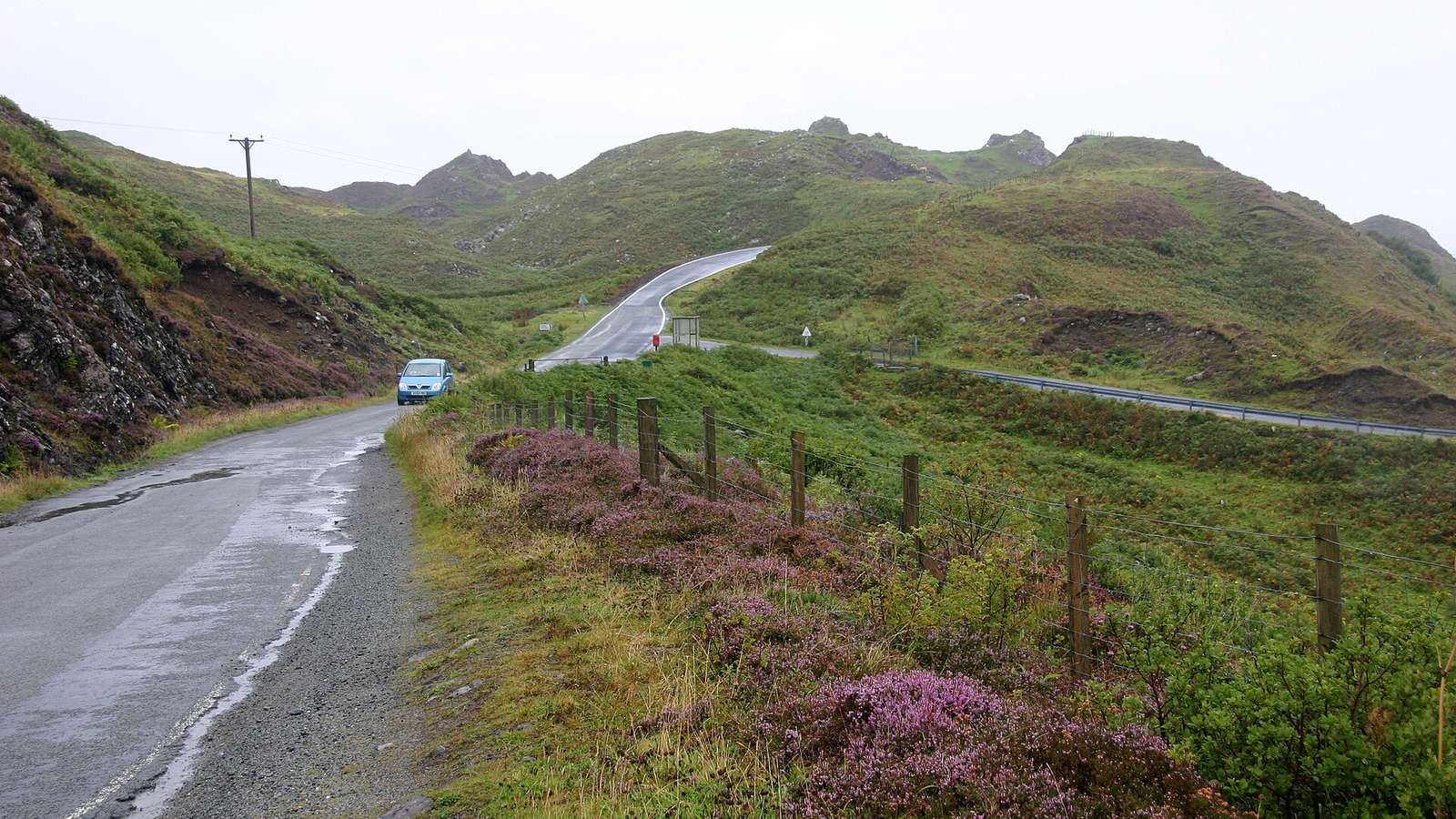 File photo of the A855 on the Isle of Skye, taken in 2009, with a single-track road climbing between heather and green hills under grey sky