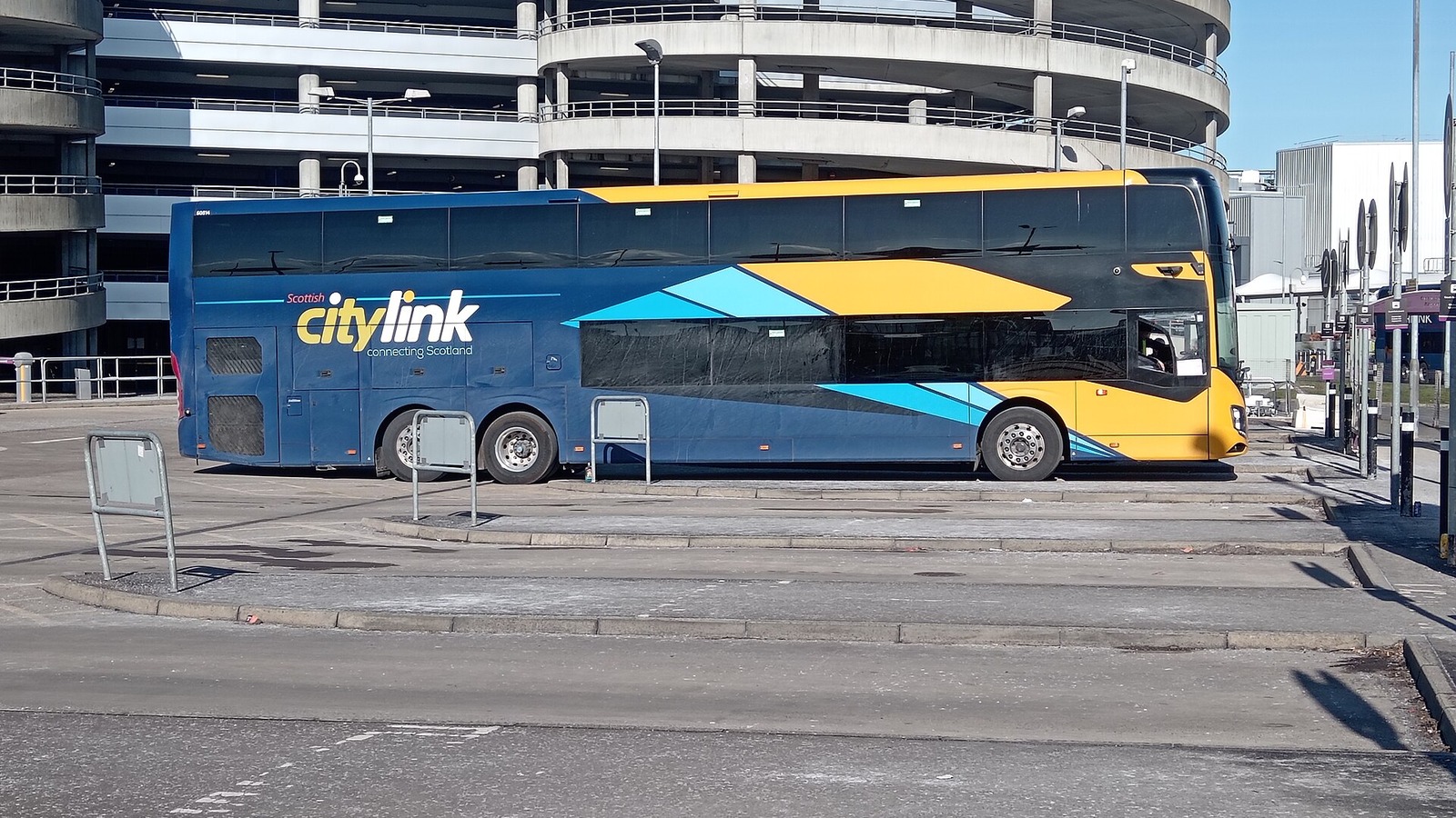 A Scottish Citylink coach at a bus stand next to a multi-storey car park