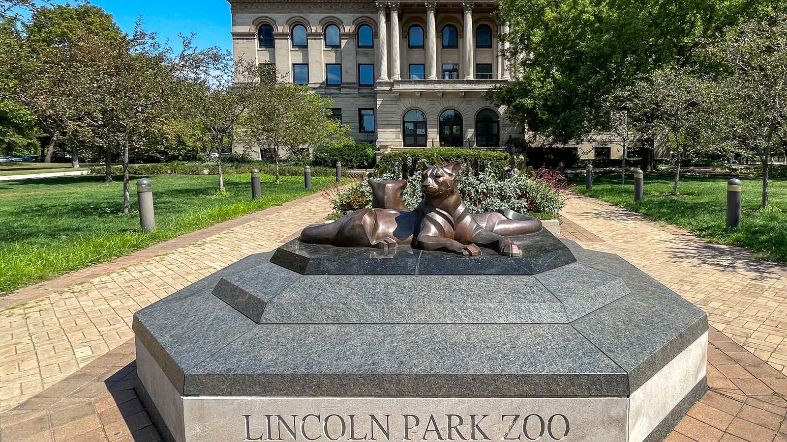 Lincoln Park Zoo sign and lion sculpture at the zoo entrance in Chicago on a sunny day