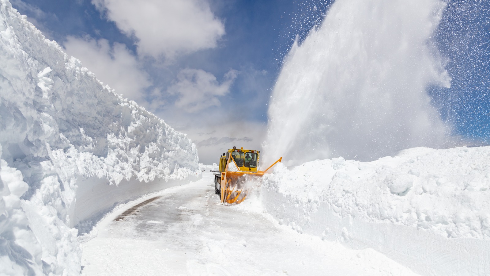 A snowplow clearing the Beartooth Highway through snowy mountains