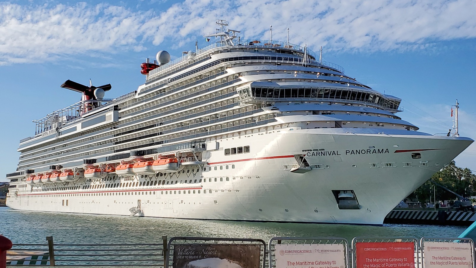Carnival Panorama cruise ship docked in daylight showing the full starboard side and bow name