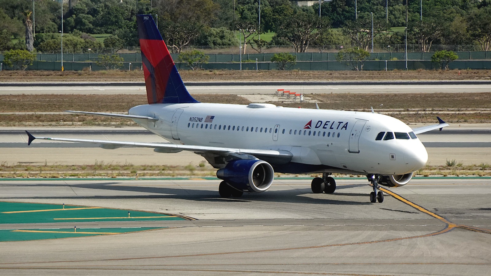 Delta Air Lines Airbus A319 taxiing on a sunlit taxiway at Los Angeles International Airport