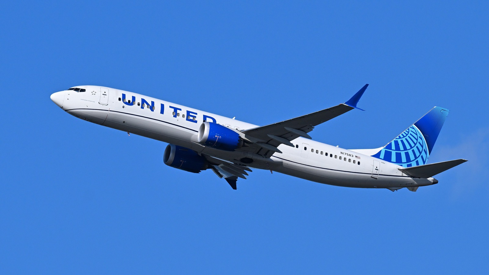 A United Airlines Boeing 737-9 MAX in the airline's blue and white livery climbing after takeoff against a clear blue sky.