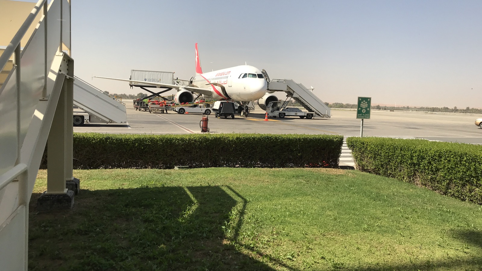 Air Arabia Airbus A320 on the airside apron at Ras Al Khaimah International Airport with terminal buildings behind