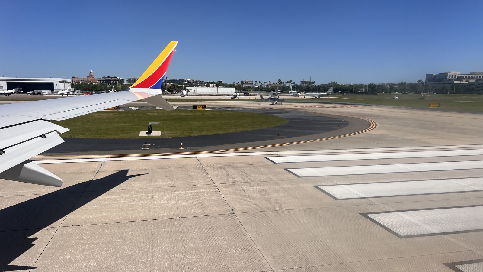 Daytime view across the airfield at Tampa International Airport with a Southwest jet tail, taxiways and terminal buildings.