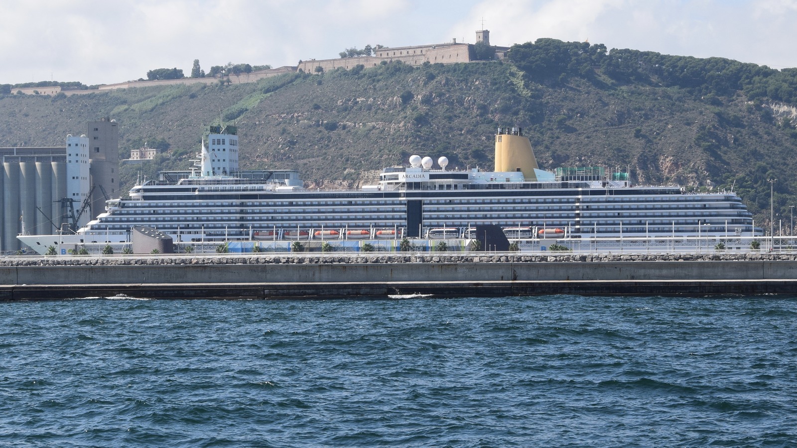 P&O Cruises ship Arcadia at a Barcelona quay, with the yellow funnel and the name Arcadia visible on the superstructure
