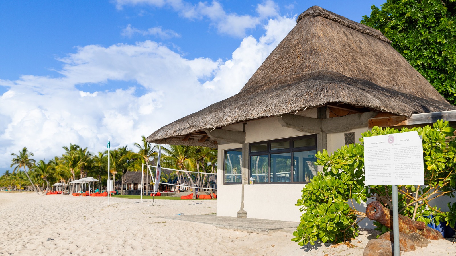 Thatched beach building and palm trees on Le Morne beach in Mauritius under a blue sky, in a file photo