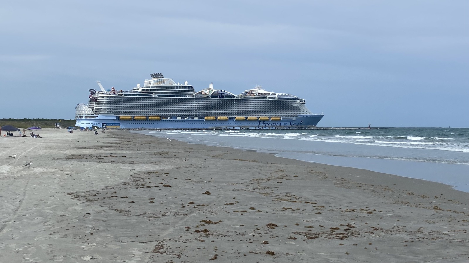 A large Royal Caribbean cruise ship departing Port Canaveral, Florida, seen from the beach in September 2026