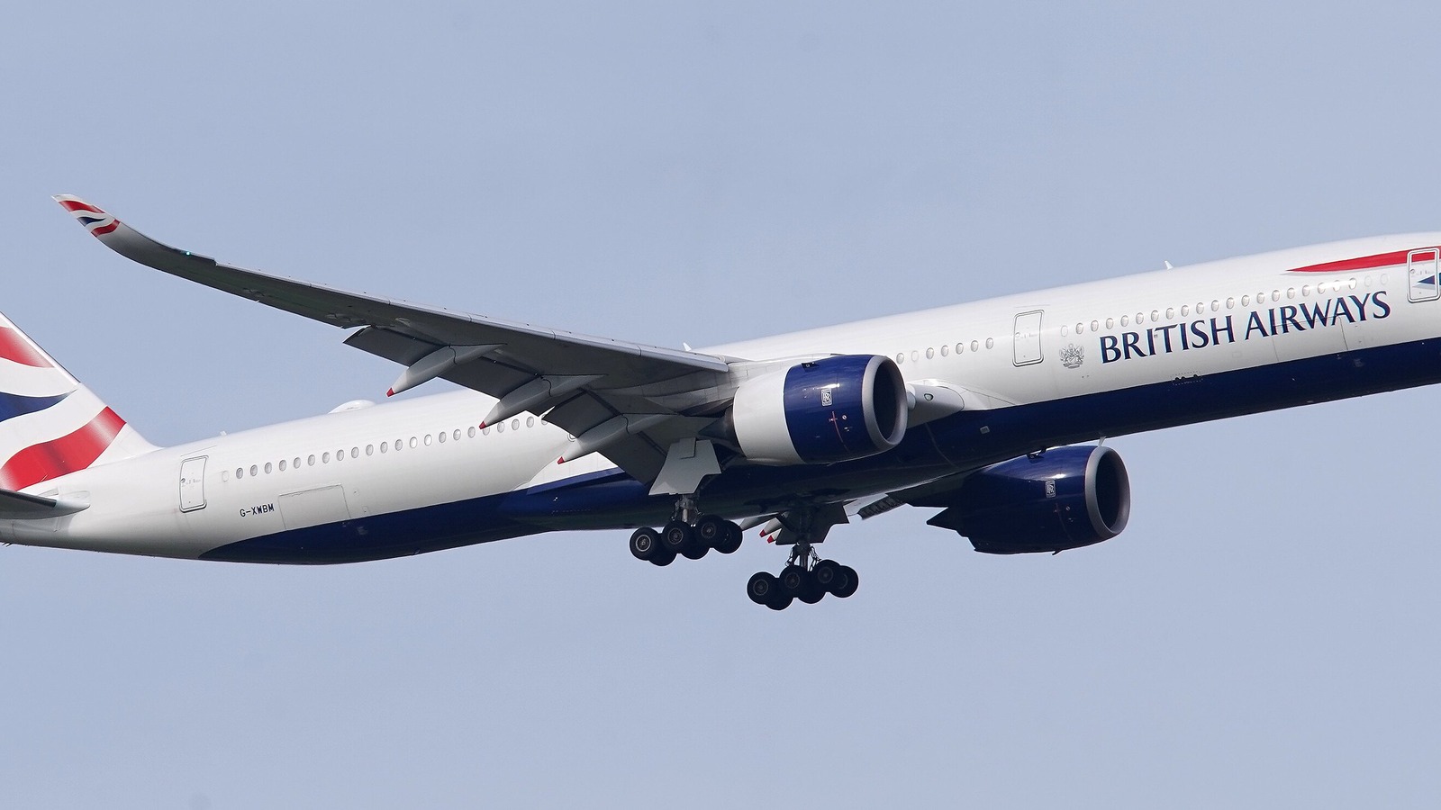 A British Airways Airbus A350-1000 on approach against a pale blue sky