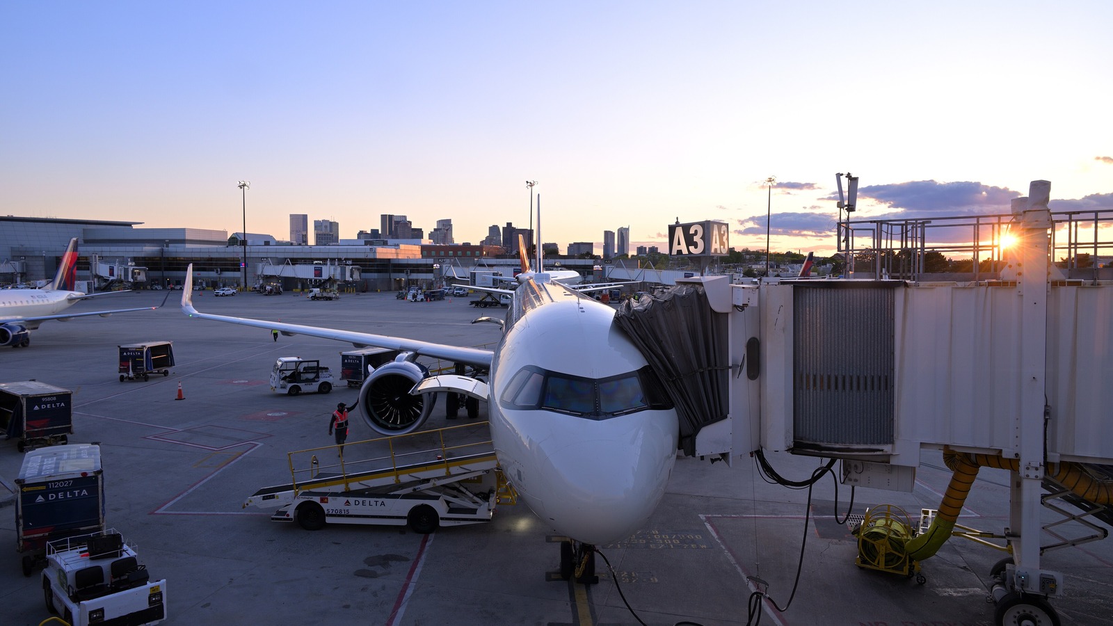 Delta Air Lines Airbus A321neo at gate A3 at Boston Logan Airport at sunset with the city skyline behind