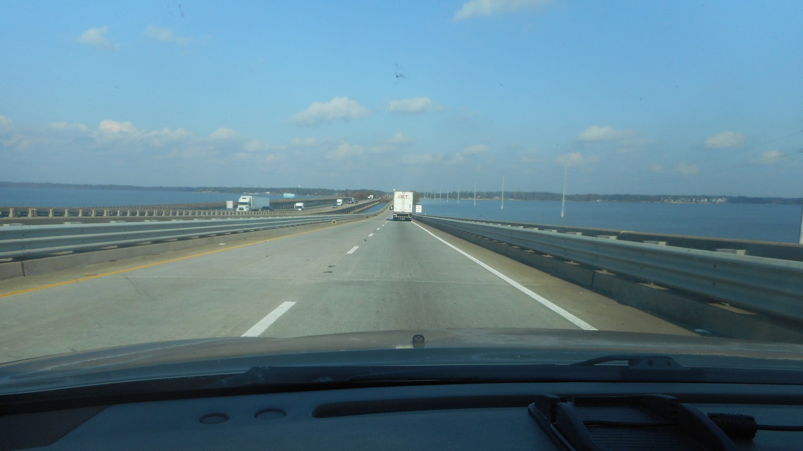 Northbound view descending the I-95 bridge over Lake Marion between Santee and Adams Landing under a clear sky, with trucks ahead on the deck