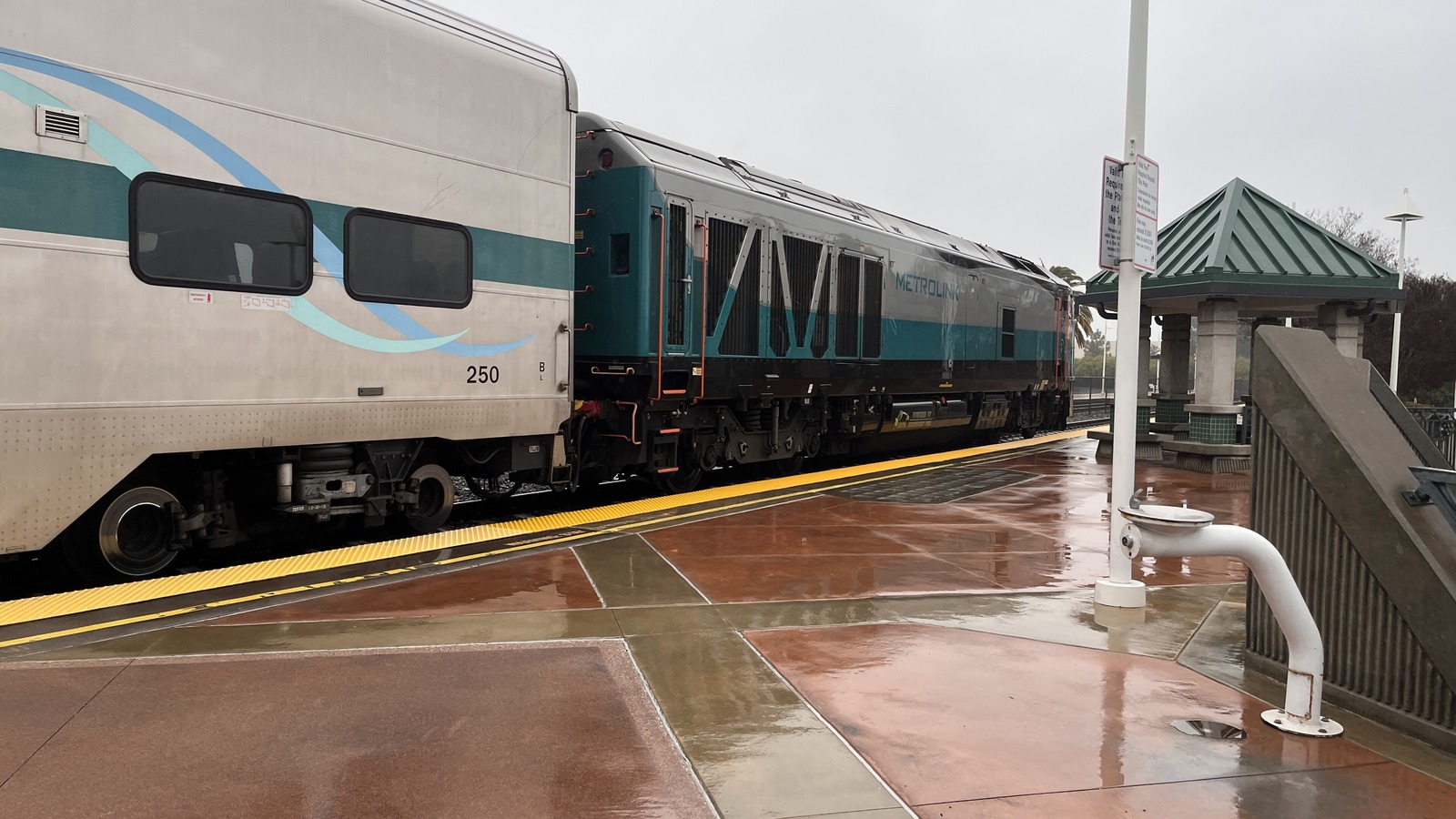 A Metrolink locomotive and passenger car at a station platform in Southern California