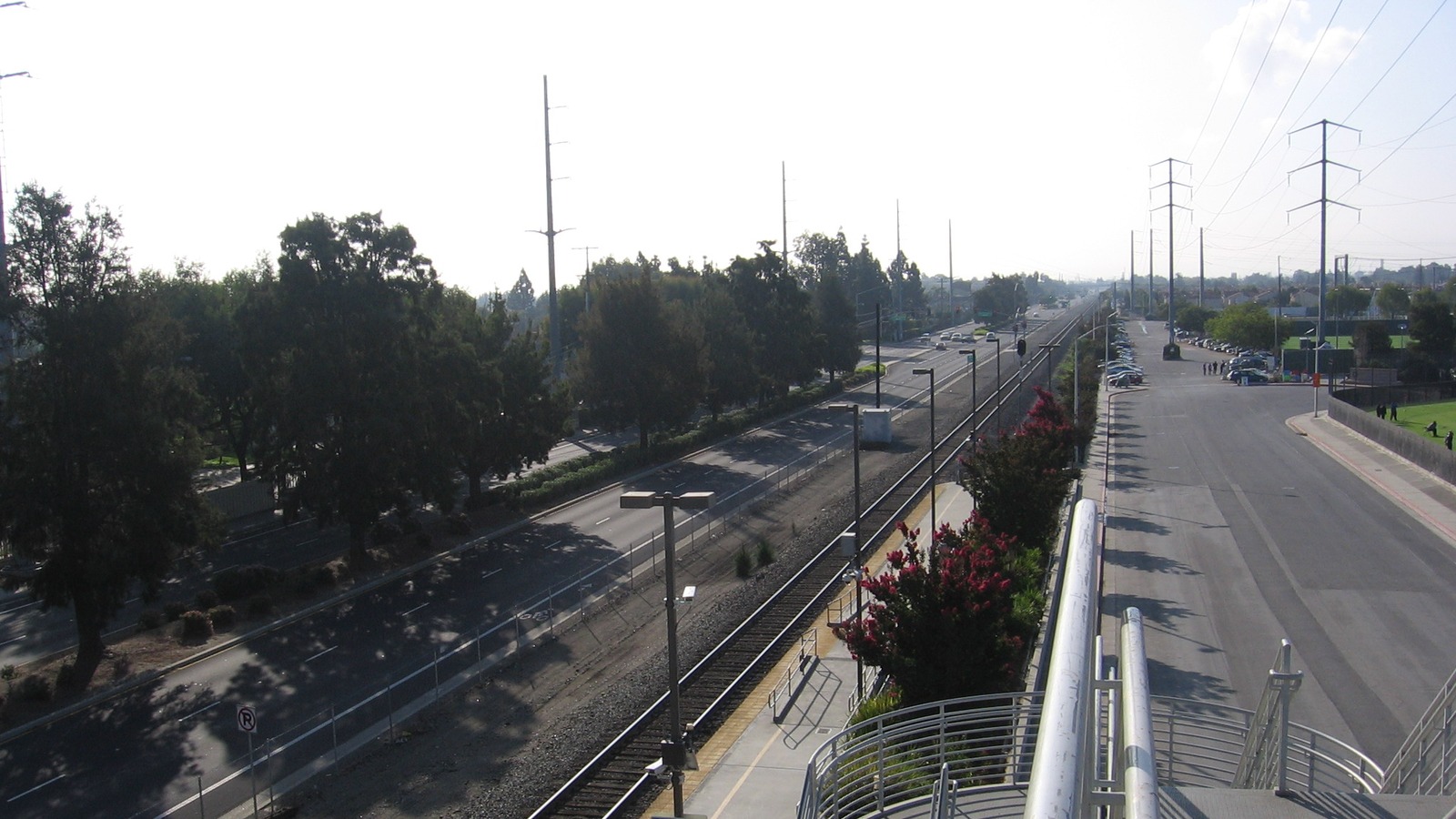 Overpass view of Santa Clara-Great America station platform, tracks, and adjacent road in Santa Clara, California
