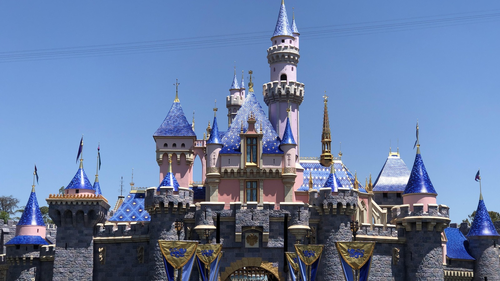 Sleeping Beauty Castle at Disneyland in Anaheim with guests on the plaza under a clear sky
