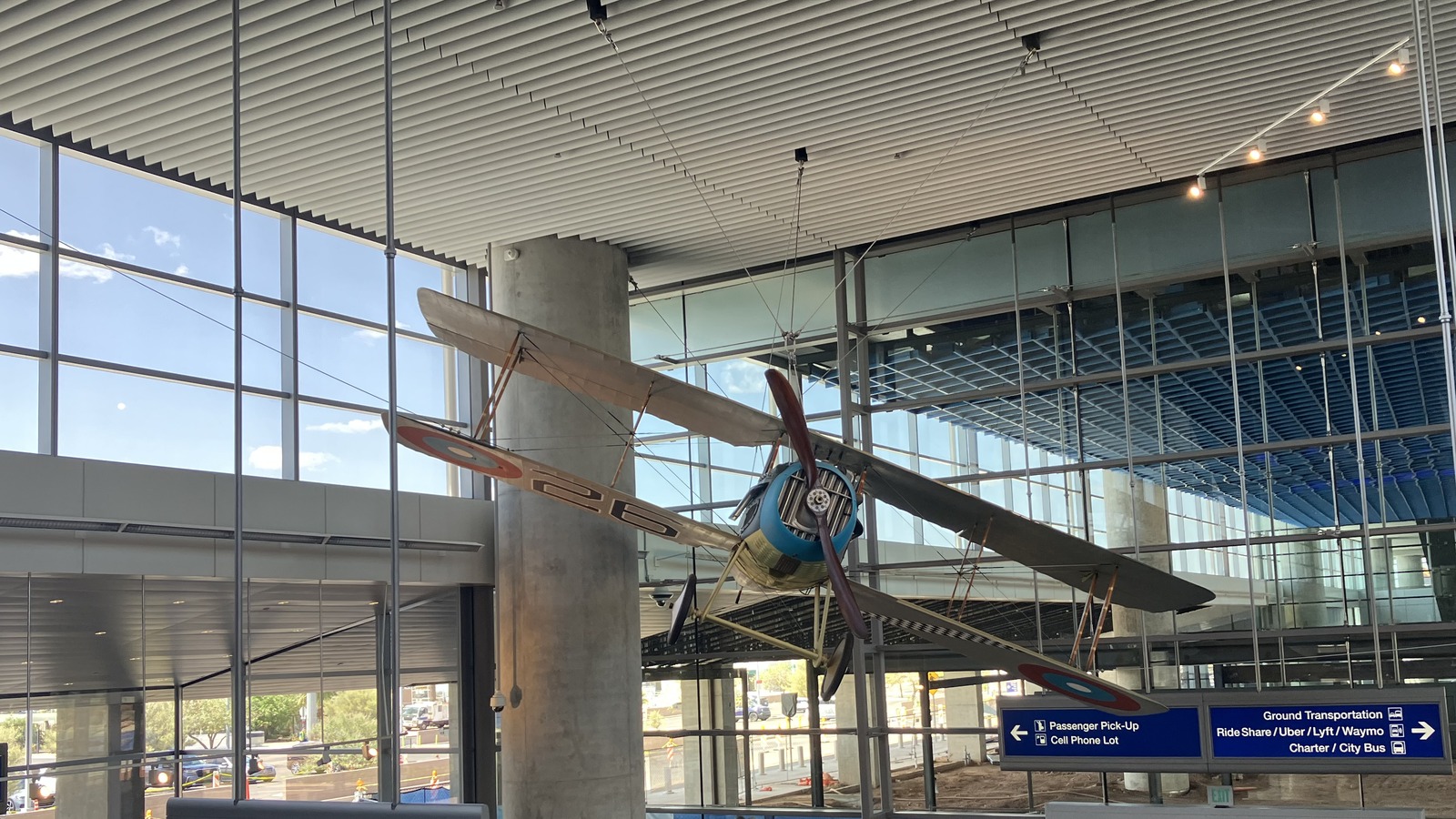 Phoenix Sky Harbor terminal interior with a suspended biplane and airport transport signs on April 27, 2025, before the disruption