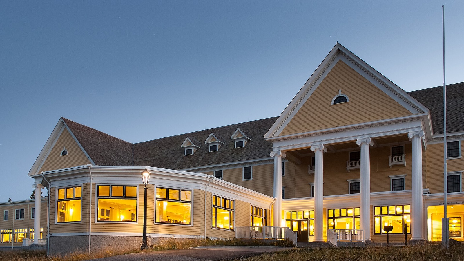 Lake Yellowstone Hotel exterior at dusk with lit windows and white columns